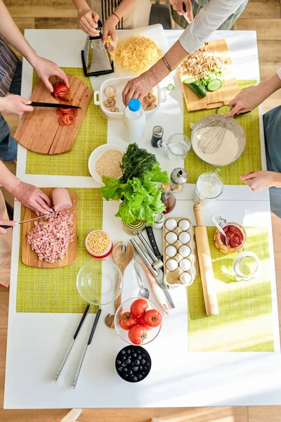 Yemek pişirme sürecinin en üst görüntüsü. Kesilmiş kadınlar pizza yapmak için hazırlanıyor. — Stok fotoğraf