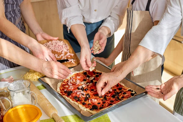 Kesilmiş kadınlar pizzaya mantar ve sosis ekliyor, evde pişirme zamanı. — Stok fotoğraf