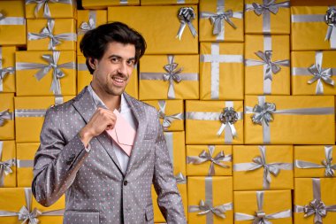 Genç beyaz bir adam ceketinden sertifikasını çıkarıp birine sunuyor.