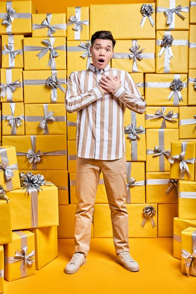 Joven chino chico en casual camisa es sorprendido por conseguir muchos regalos para cumpleaños — Foto de Stock