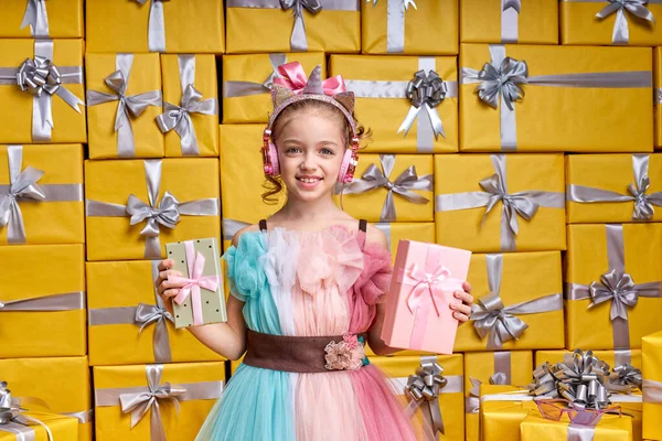 Hermoso positivo feliz niña pequeña usando vestido de fiesta celebración de caja de regalo y divertirse — Foto de Stock