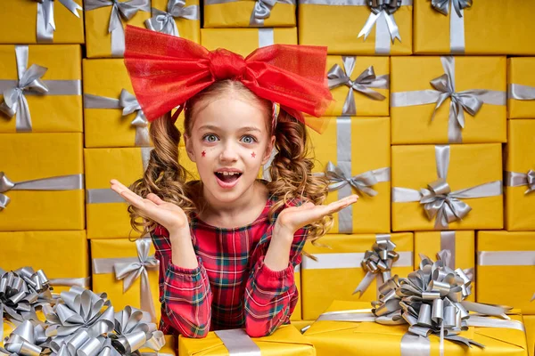 Alegre niña caucásica en soporte de desgaste a cuadros entre los regalos — Foto de Stock