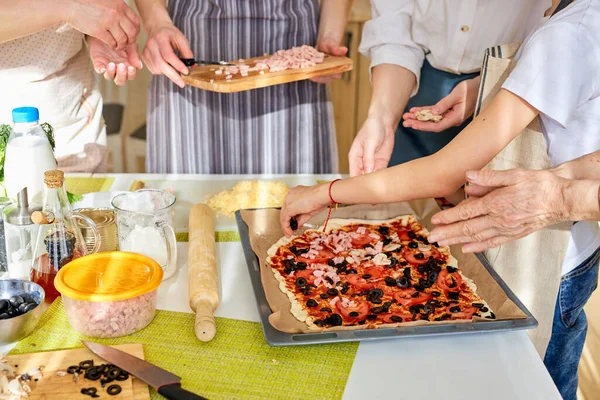 Kesilmiş kadın elleri pizzaya malzeme ekliyor, bütün aile için lezzetli pizza hazırlıyor. — Stok fotoğraf