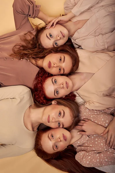 Grupo de belos modelos, amigos, irmãs com cabelo vermelho natural longo estava no fundo bege — Fotografia de Stock