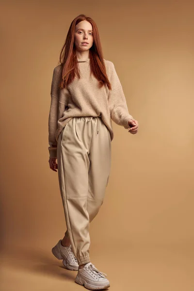 Coup de mode. Jolie jeune mannequin féminine aux longs cheveux roux posant en studio — Photo