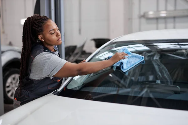 Vrouwelijke arbeider in grijs uniform schoonmaakauto. auto detaillering en valeting, service concepten — Stockfoto