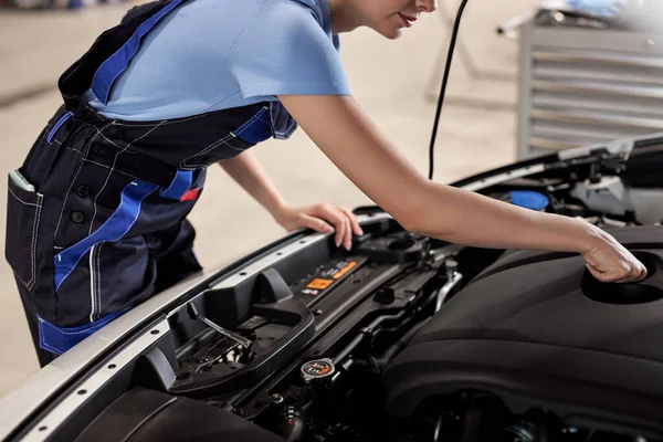 Vrouwelijke auto monteur onderzoeken auto motorpech probleem in de auto service — Stockfoto