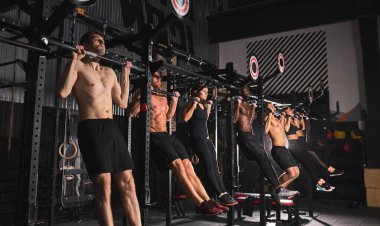 Spor salonundaki barda çalışan güçlü atletik erkek ve kadınlar.