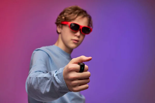 Teenage boy in virtual reality glasses enjoying 3D gadget technology, controllers on fingers — Stock fotografie