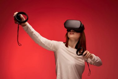 Stüdyoda sanal gerçekliğin video kulaklığını kullanarak deneyim kazanan genç bir kadın.