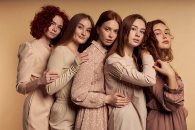 Sevimli kızıl saçlı, omuz omuza yaslanan genç kadınlar bej rengi, pankartta izole edilmiş.