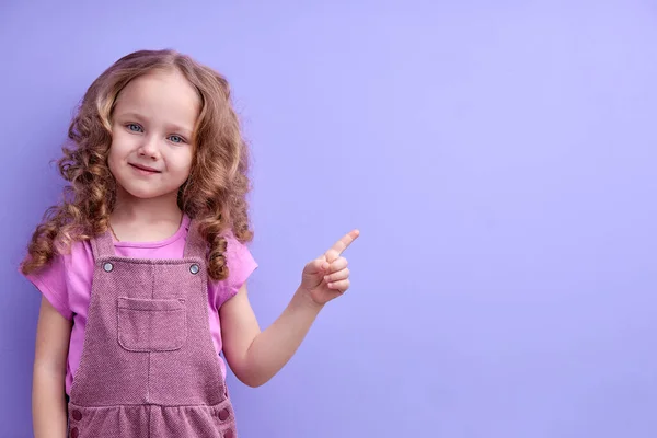 Petite fille en chemise rose montre doigt. Concept de publicité, attention au sujet ou aux mots — Photo
