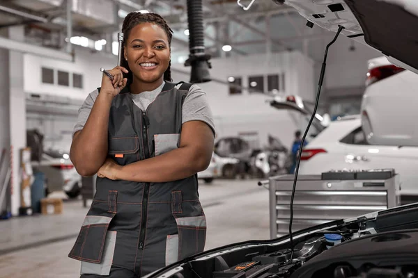 Glimlachen afro vrouwelijke auto reparateur, met een pauze, kijken naar de camera — Stockfoto