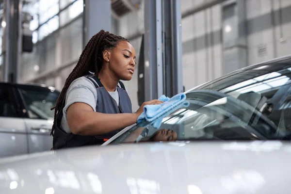 Afro vrouw polijsten schoonmaken auto met microvezel doek, auto detaillering of valeting concept — Stockfoto