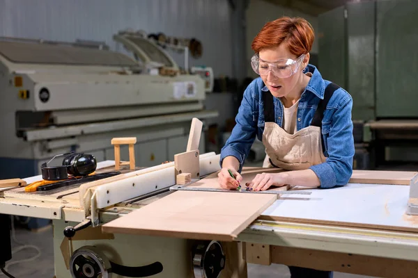 Confiante focado profissional carpinteiro sério mulher segurando régua e lápis — Fotografia de Stock