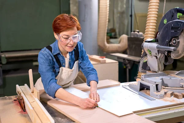 Trabalhando duro carpinteiro feminino trabalhando como designer de madeira em pequena oficina de carpintaria — Fotografia de Stock