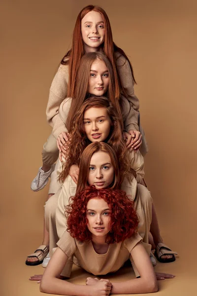 Positivi modelli dai capelli rossi isolati su sfondo beige studio, l'uno sull'altro — Foto Stock