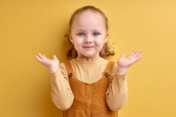 Χαριτωμένο κοριτσάκι αμφιβάλλει και shrugging ώμους στην ανάκριση χειρονομία, απομονωμένη — Φωτογραφία Αρχείου