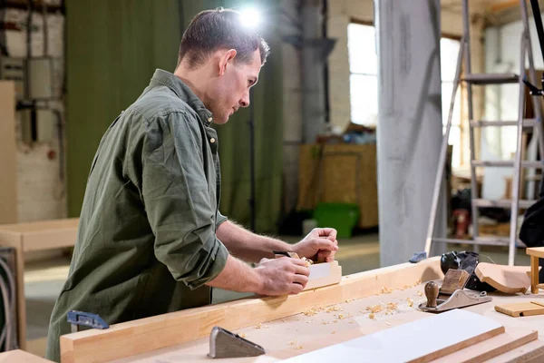 Ocupado e sério marceneiro está trabalhando com madeira. carpinteiro profissional na loja de joiners — Fotografia de Stock