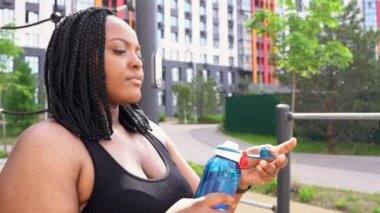 Kilolu bir kadın spor yaptıktan sonra suya batırıyor. Açık hava