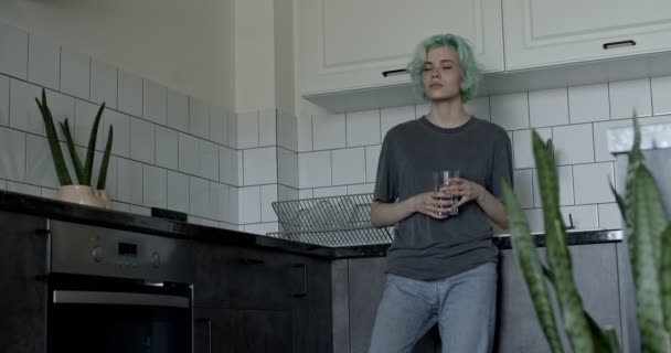 Προνοητική Καυκάσια γυναίκα σε περιστασιακή στολή στο σπίτι στην κουζίνα πόσιμο νερό — Αρχείο Βίντεο