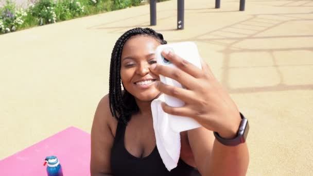 Adorabile donna africana scattare foto selfie su smartphone, seduto all'aperto dopo l'allenamento — Video Stock