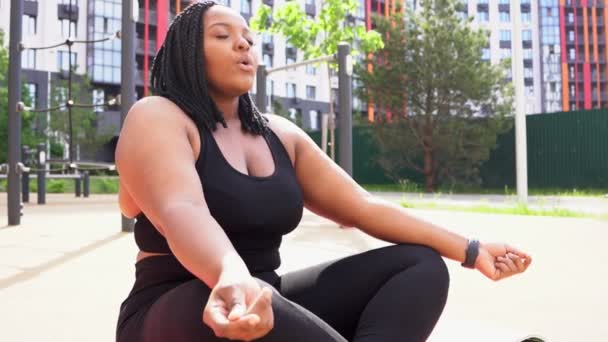 Donna afro-americana in sovrappeso condurre uno stile di vita sano, impegnato in yoga all'aperto — Video Stock