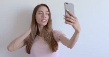 Cep telefonu kamerasında sıradan pozlar veren, gülümseyen, doğal güzelliğin tadını çıkaran hoş bir kadın.