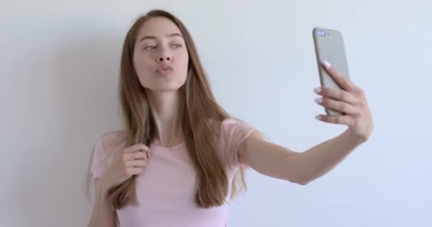 Jonge vrouw maken selfie foto op mobiele telefoon geïsoleerd over witte achtergrond, poseren — Stockvideo