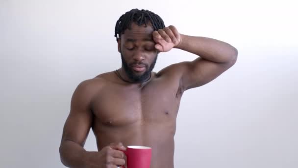 Вымотавшийся афро-спортсмен отдыхает после спортивных упражнений, пьет воду — стоковое видео