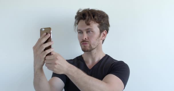 De levensstijl van mensen. jong Kaukasische man het nemen van selfie en kijk naar foto op smartphone — Stockvideo