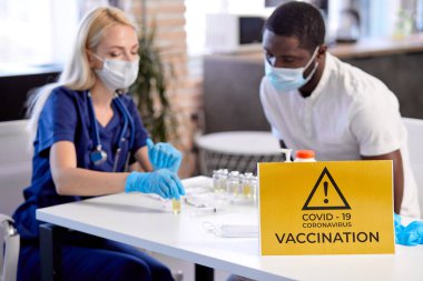 Kadın doktor hastayı koronavirüs aşısı için hazırlıyor. Tıp konsepti.