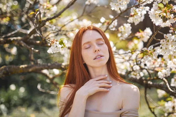 Calme sensuel élégant modèle toucher la peau, posant dans les arbres de fleurs de printemps, copier l'espace — Photo