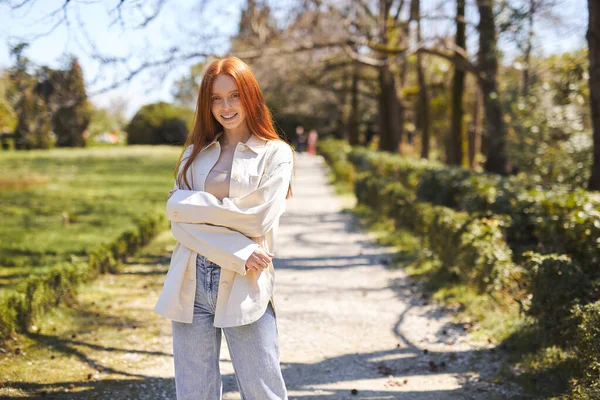 春の公園を歩くカジュアルな服装の正の女性。自然散策や暖かい夏の日 — ストック写真