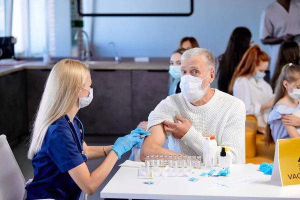 Äldre kaukasiska mannen att få Spruta injektion i axeln av professionell läkare — Stockfoto