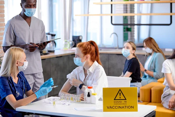 Vaccin dans la main d'une jeune patiente caucasienne. Le concept de vaccination de masse — Photo