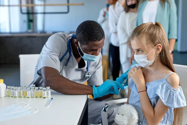 En injektion med vaccin i händerna på en flicka, massvaccinering under 2021 pandemi — Stockfoto