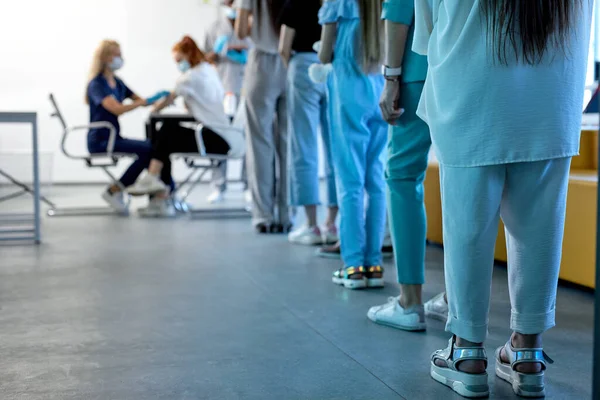 Taustakuva jonossa ihmisistä potilaat valmiina joukkorokotukseen sairaalassa — kuvapankkivalokuva