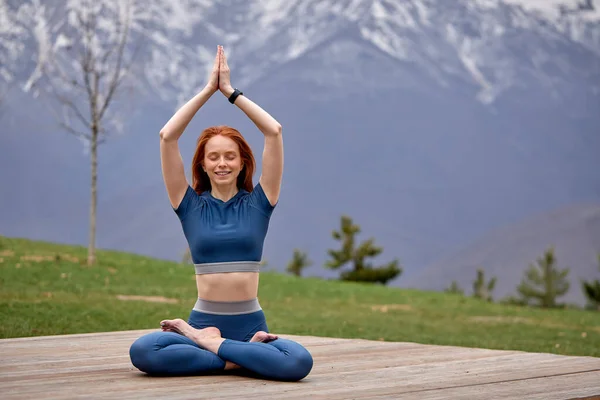 Morning Exercises in mountains landscape. Young slim Woman doing Yoga outdoor in morning