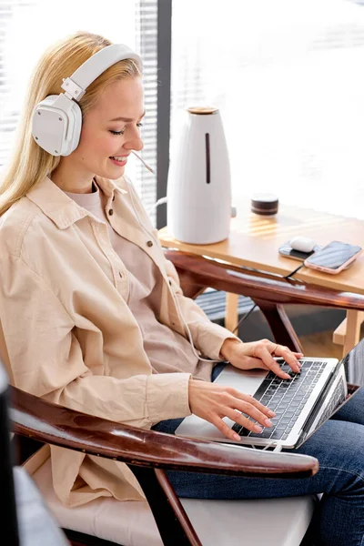 Trabajo en casa, trabajo inteligente. femenino utiliza portátil y dispositivos modernos, sonrisa —  Fotos de Stock