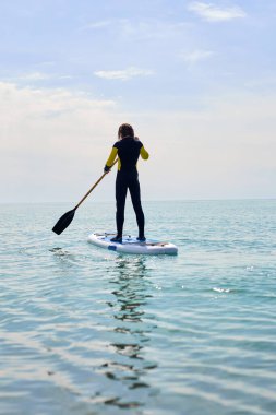 Siluet sporcusu ayağa kalk, sörf tahtasında ya da sörf tahtasında, spordan zevk al.