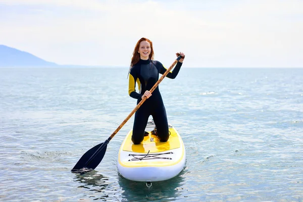 SUP Stand up paddle board. sorrindo Jovem mulher navegando em belo mar calmo — Fotografia de Stock