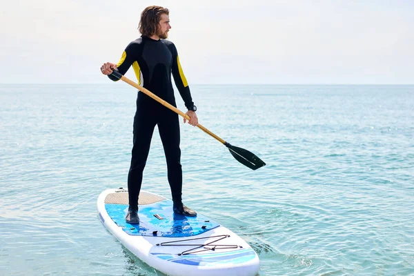 Ajuste joven barbudo surfista hombre subsurf en mar abierto o mar. Estilo de vida moderno —  Fotos de Stock