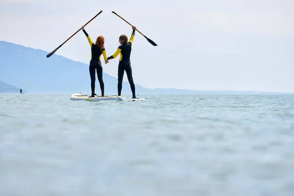 Silhouette de couple paddleboard en mer, loisir sport pagaie océan plage surf — Photo