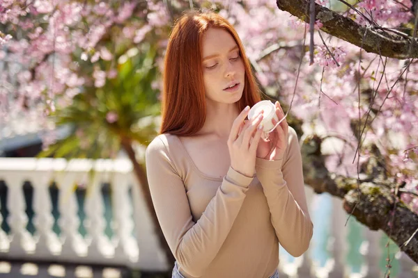 庭でポーズをとる若い魅力的なエレガントな女性ピンクの春の花の木の近く — ストック写真