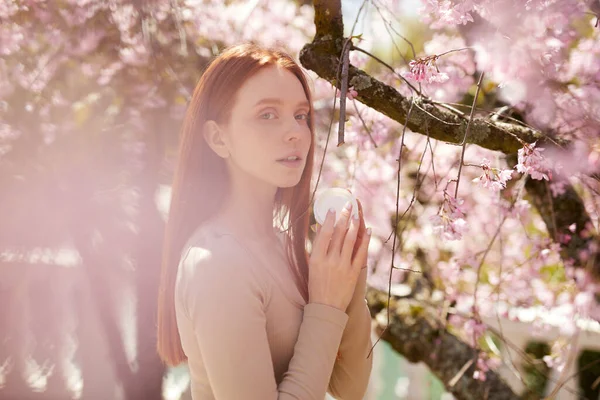 庭、ピンクの春の花の木の近くにポーズをとって愛らしい美しいエレガントな女性 — ストック写真