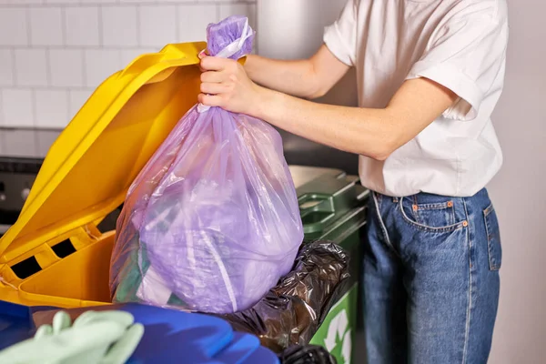 recycling, waste sorting and sustainability concept. cropped woman throwing rubbish