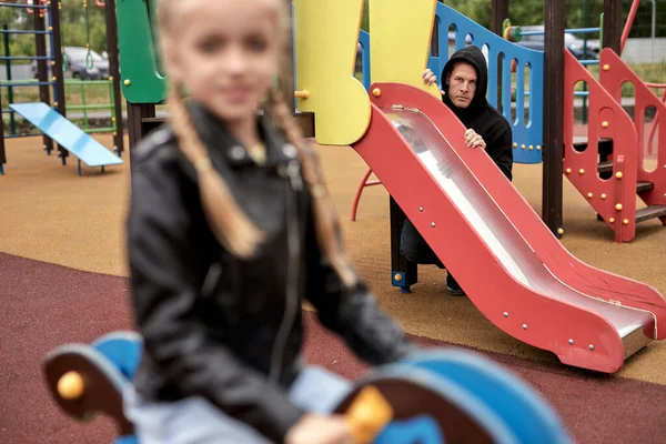 Assault and kidnapping. Victims are children of rapist. Maniac on playground, chasing girl — Stock Photo, Image