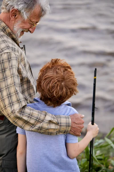 Visão traseira no menino branco bonito amigável da criança veio pescar com o avô — Fotografia de Stock