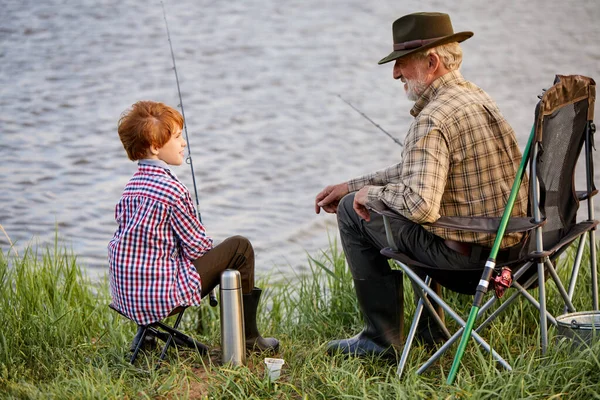 Caucasian multi-generation family fishing together. Boy with grandfather fishing outdoor